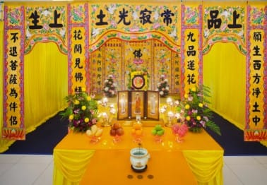 Traditional Buddhist funeral setup by Ang Chin Moh with ornate carvings and ritual offerings.