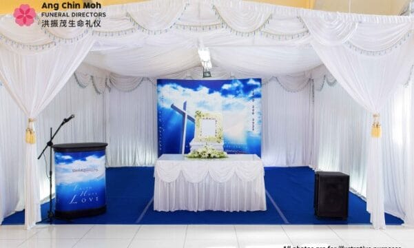 Modern Christian funeral service arrangement by Ang Chin Moh with simple white floral accents.