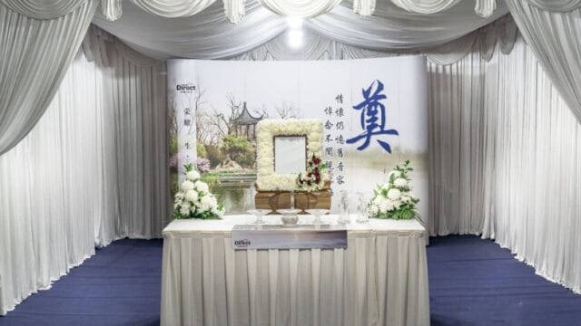 Traditional Taoist funeral wake setup with ceremonial altar and ritual floral decorations.