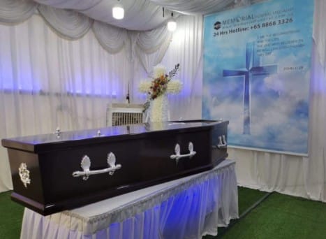 Modern Christian funeral service arrangement by Memorial Funeral with simple white floral accents.
