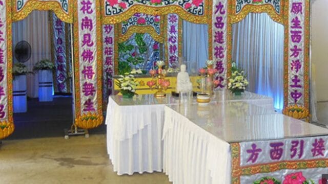 Traditional Buddhist funeral altar setup at Simplicity Casket with ritual offerings.