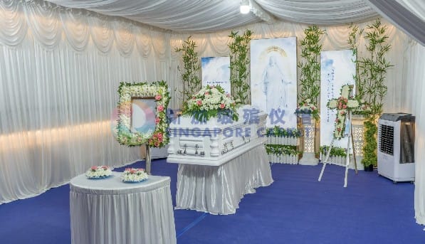 Catholic funeral wake setup at Singapore Casket featuring a crucifix and elegant white drapes.