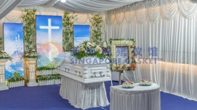 Christian funeral service setup at Singapore Casket with a cross backdrop and floral wreaths.