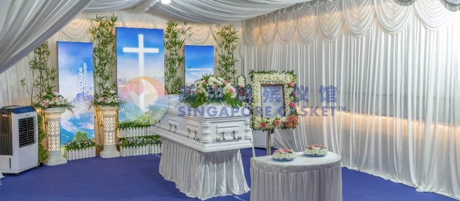 Christian funeral service setup at Singapore Casket with a cross backdrop and floral wreaths.