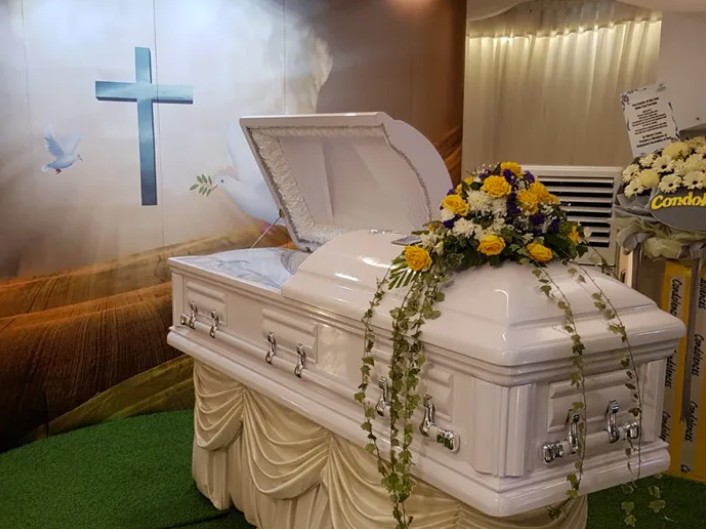 Christian funeral casket with floral arrangement by Eternity Funeral Service in Singapore
