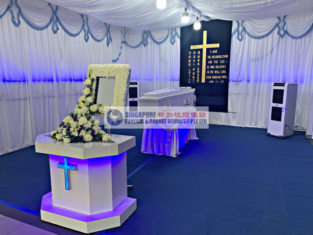 Christian funeral wake setup by Singapore Funeral & Casket Services with illuminated cross backdrop