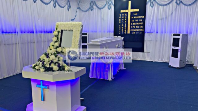 Christian funeral wake setup by Singapore Funeral & Casket Services with illuminated cross backdrop